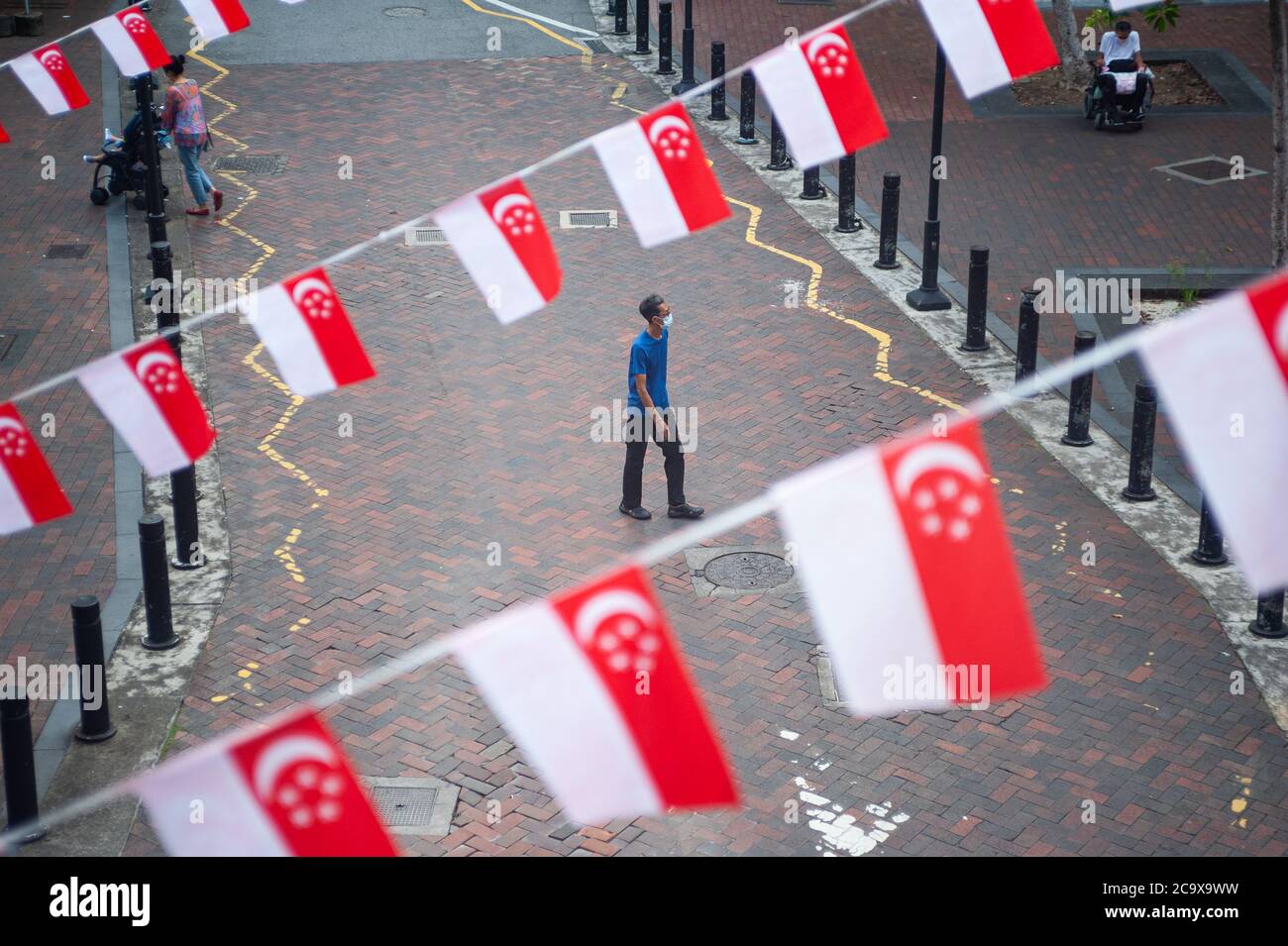 16.07.2020, Singapur, Republik Singapur, Asien - kleine Flaggen in den Nationalfarben des Stadtstaates, die als Wimpelbanner über der Straße schweben. Stockfoto