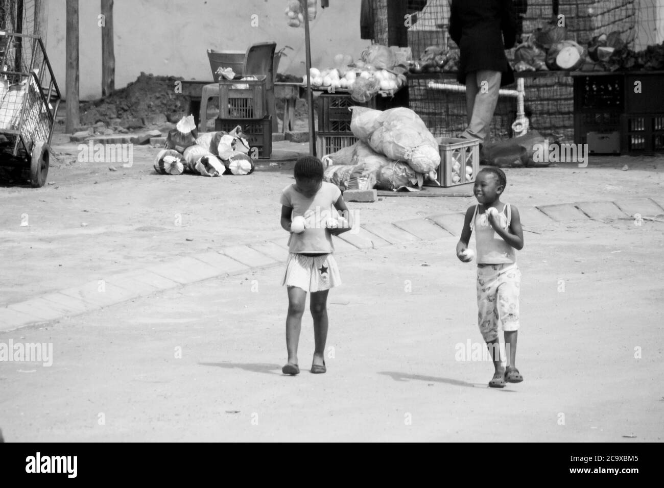 Ein paar Kinder, nachdem sie Obst gekauft hatten, gingen die Straße hinunter in SOWETO in Johannesburg in SA. Stockfoto