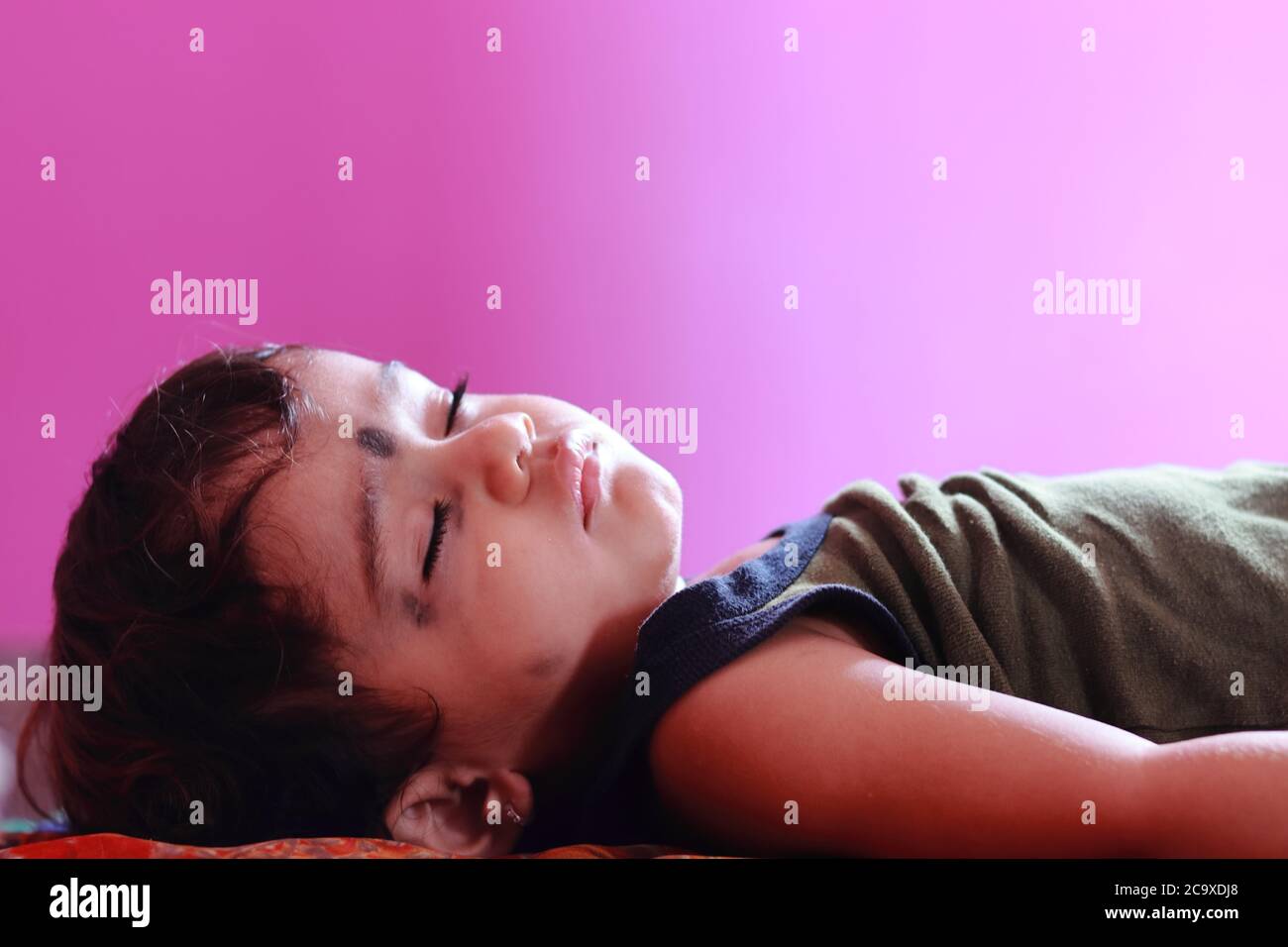 Ein schönes Baby schlafen im Zimmer mit verschwommen rosa Zimmerwand, kostenlos Kind Bilder Stockfoto