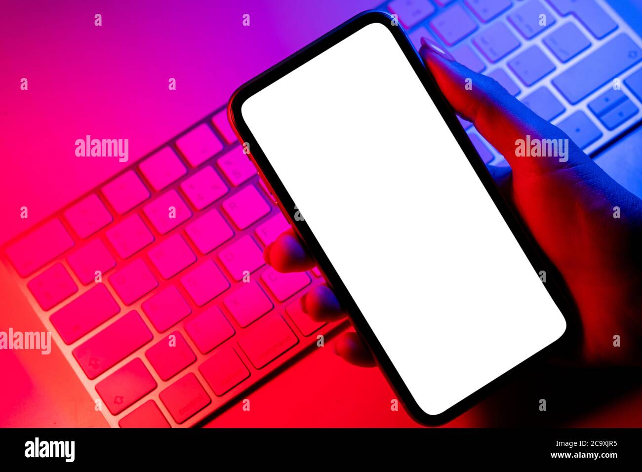 Smartphone Mockup in Frau Hand in blauen und rosa Tönen. Rahmenlose Smartphone-Modell mit leerem weißen Bildschirm. Leeres Leerzeichen für Text. Speicherplatz kopieren. Isolat Stockfoto
