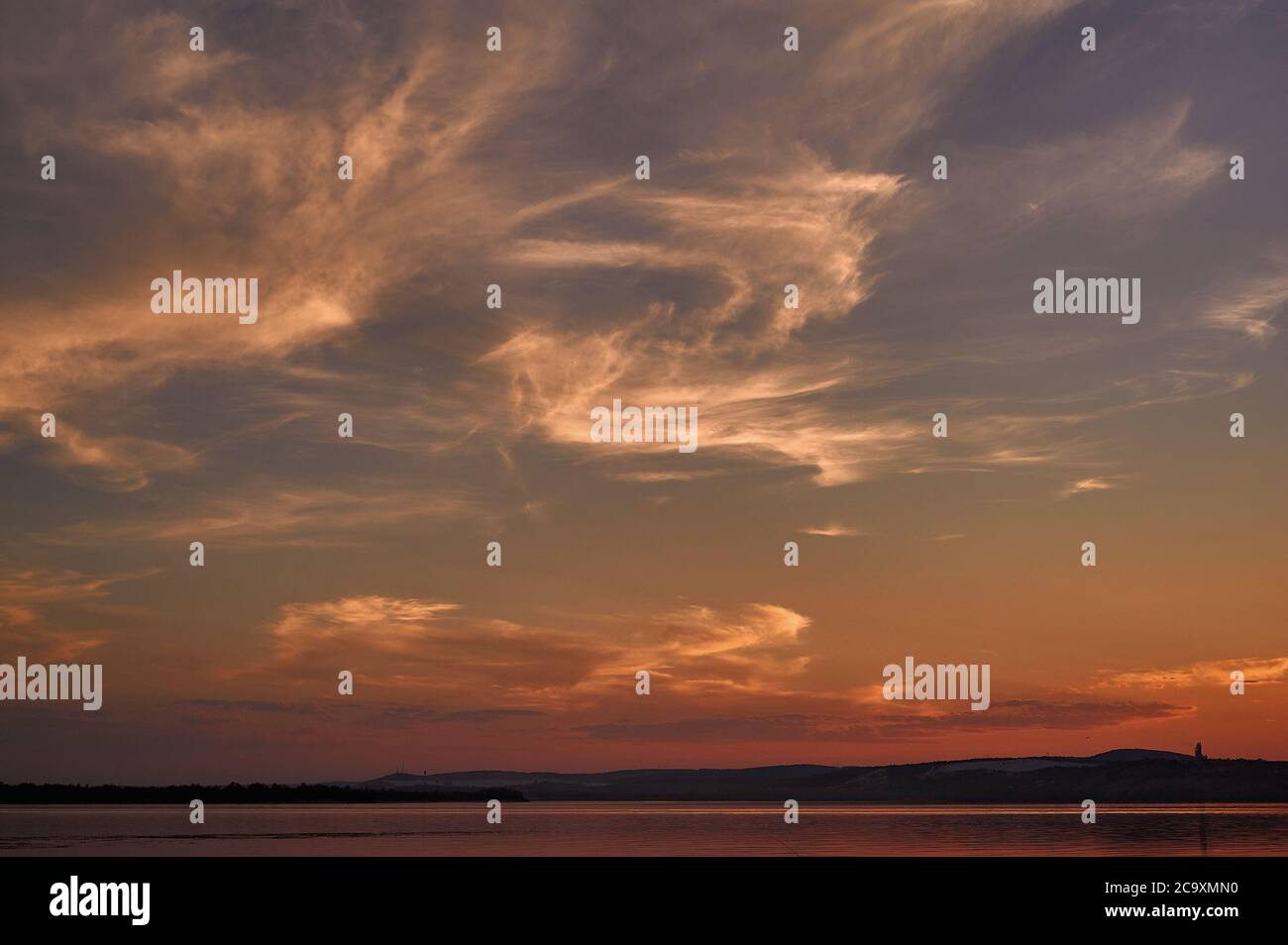 Himmel bei Sonnenuntergang in warmen Tönen und melierten Blöcken Stockfoto