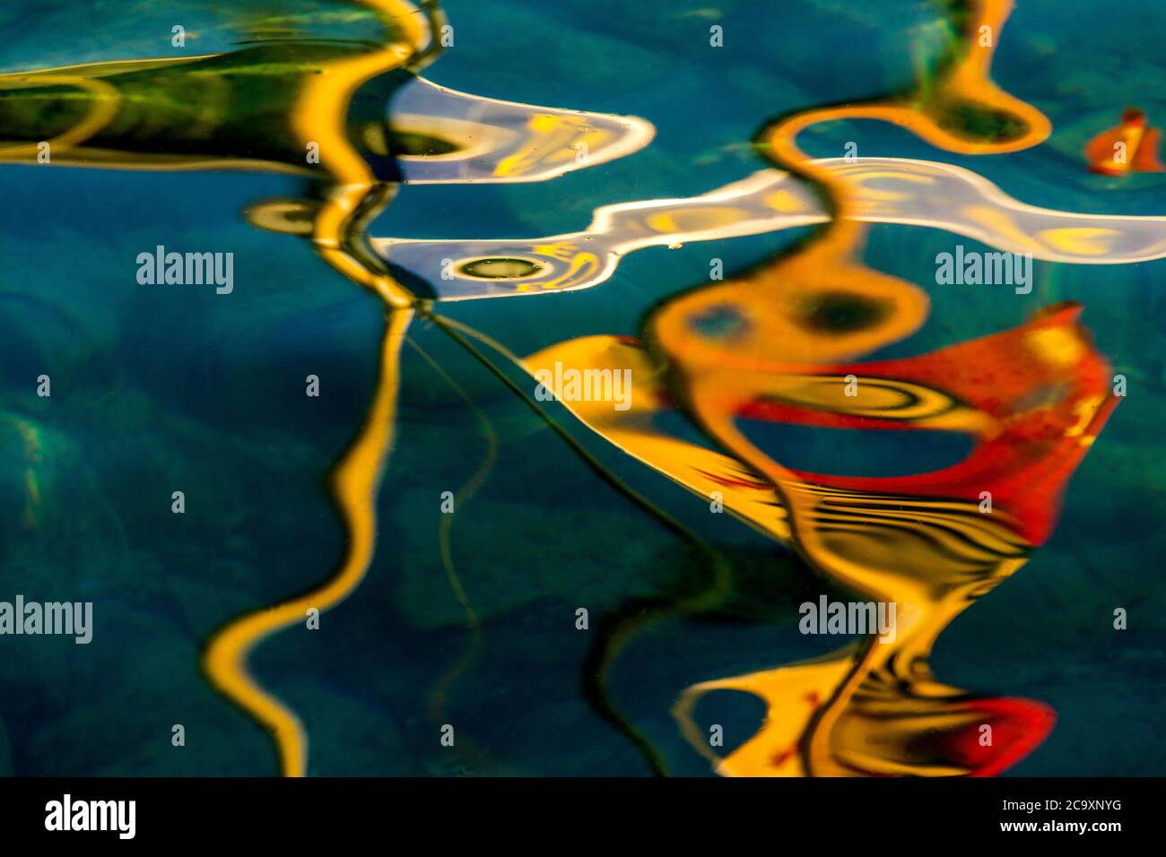 Reflexionen des Sonnenlichts erzeugen abstrakte Muster auf der Wasseroberfläche am späten Nachmittag Stockfoto