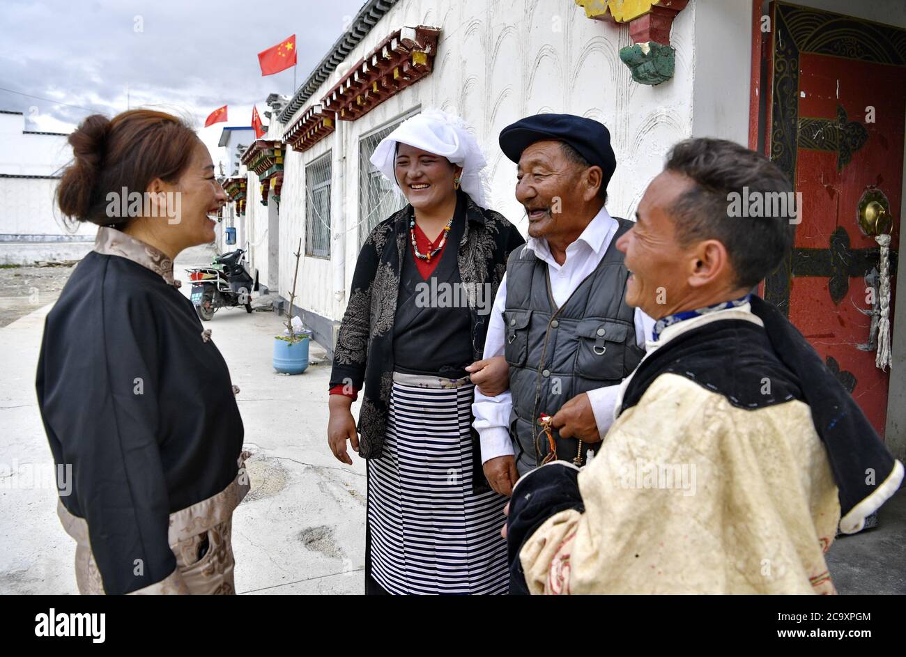 (200803) -- LHASA, 3. August 2020 (Xinhua) -- EIN Dorfbeamter, der für die Frauenarbeit zuständig ist (1. L), spricht mit Dorfbewohnern des Umzugsdorfes Caiqutang in der Gemeinde Yangbajain, Landkreis Damxung, südwestlich der Autonomen Region Tibet, 2. August 2020. Die in den letzten Jahren durchgeführten Standortverlagerungen zur Armutsbekämpfung haben zur Förderung der ländlichen Revitalisierung in der Autonomen Region Tibet beigetragen. So bietet das Umsiedlungsdorf Caiqutang, das Ende 2017 seine ersten Umsiedler erlebte, heute 683 Einwohnern, die aus weniger liebenswürdigen alpinen Gebieten umgezogen sind, bessere Versorgung und Gesundheitsversorgung. Der Umzug Stockfoto