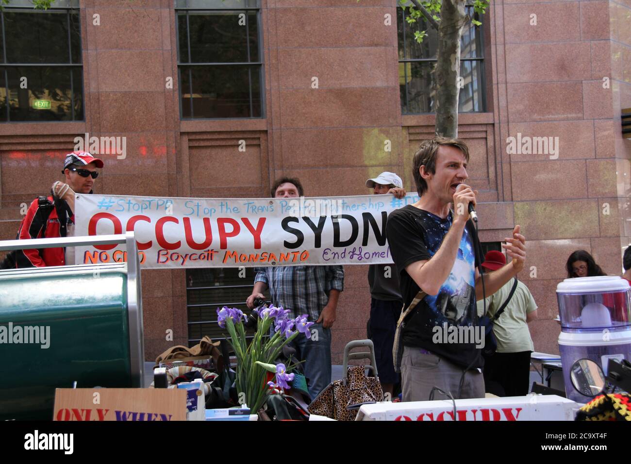 Abgebildet ist ein Sprecher, der während der Kundgebung gegen Monsanto und GVO in der Siedlung Occupy Sydney steht. Stockfoto