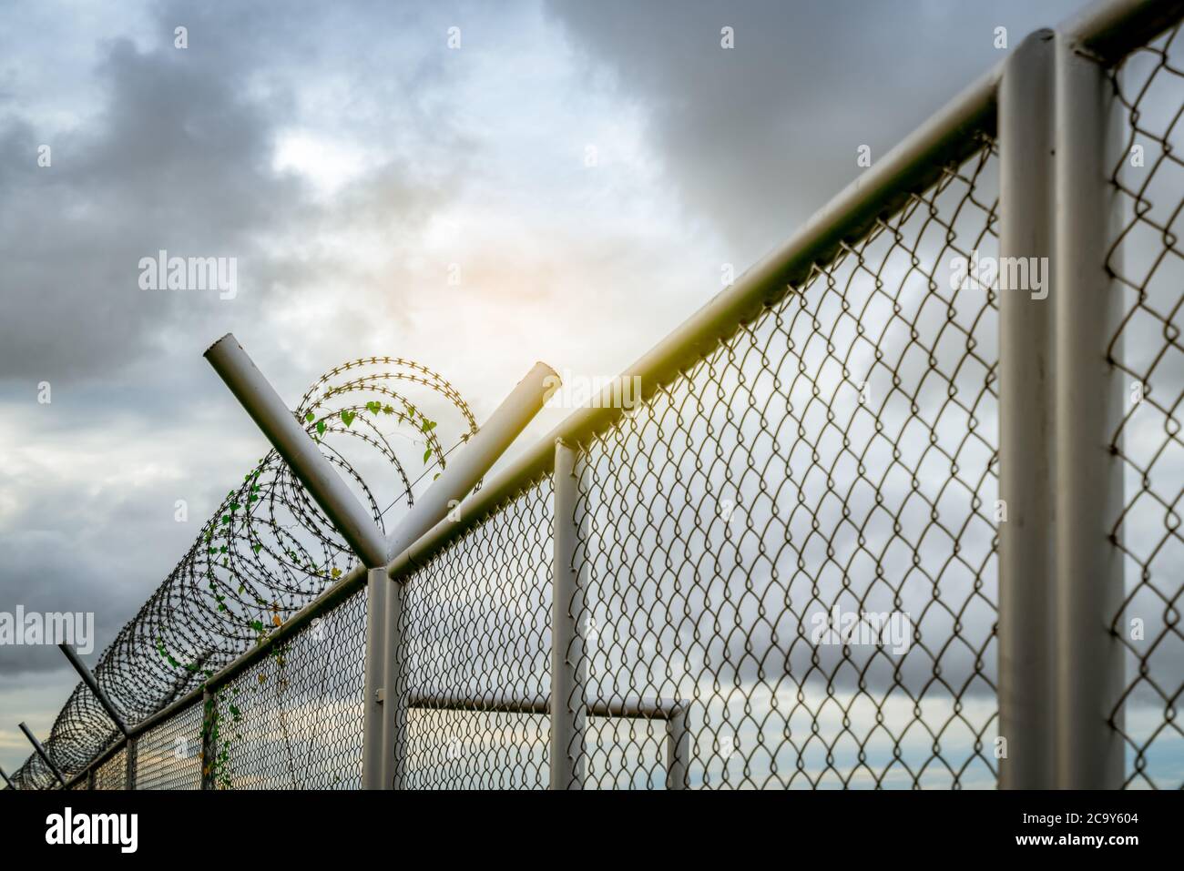 Sicherheitszaun im Gefängnis. Stacheldraht-Sicherheitszaun. Rasiermesserscharfe Gefängnismauer. Barriere Grenze. Sicherheitswand der Grenze. Gefängnis für Festnahme Verbrecher Stockfoto