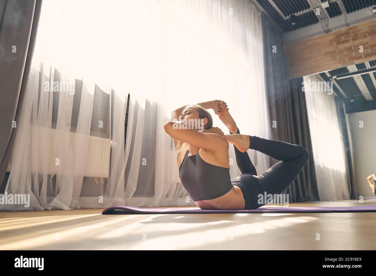 Sportliche junge Frau praktiziert Yoga im privaten Studio Stockfoto