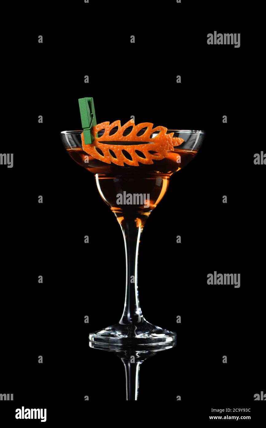 Kunst in Orange - Früchte schnitzen. Wie man zu Zitrusfrüchten garnieren Design für ein Getränk zu machen. Cocktail Rob Roy. Whiskey-basierte Getränke. Stockfoto