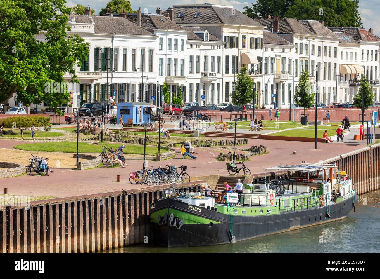 Zutphen, Niederlande - 120. Juli 2020: Sommerblick auf den IJssel Fluss und Ufer mit Menschen in der Sonne entspannen in der niederländischen Stadt Zutphen, Stockfoto