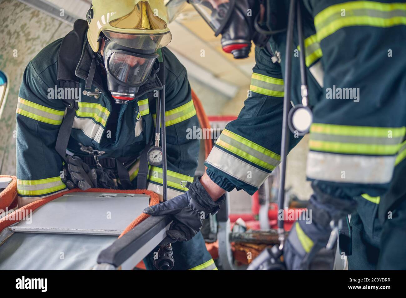 Feuerwehrleute arbeiten mit den Werkzeugen für die Auslöschung des Feuers Stockfoto