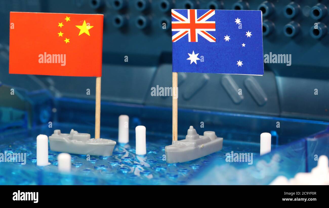 Die australische Marine und ein chinesisches Schiff mit Nationalflaggen treffen sich auf einem Schlachtschiff-Spielbrett. Südchinesisches Meer, Spratly-Inseln umstritten Stockfoto