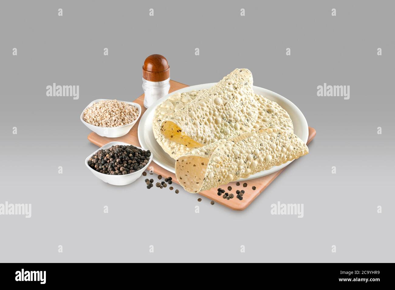 Indische Snacks, frittierte oder geröstete Mung/Urad dal Cracker oder Papad, die eine Beilage zum Mittag- und Abendessen ist. Serviert in einem Rohrkorb / Teller Stockfoto