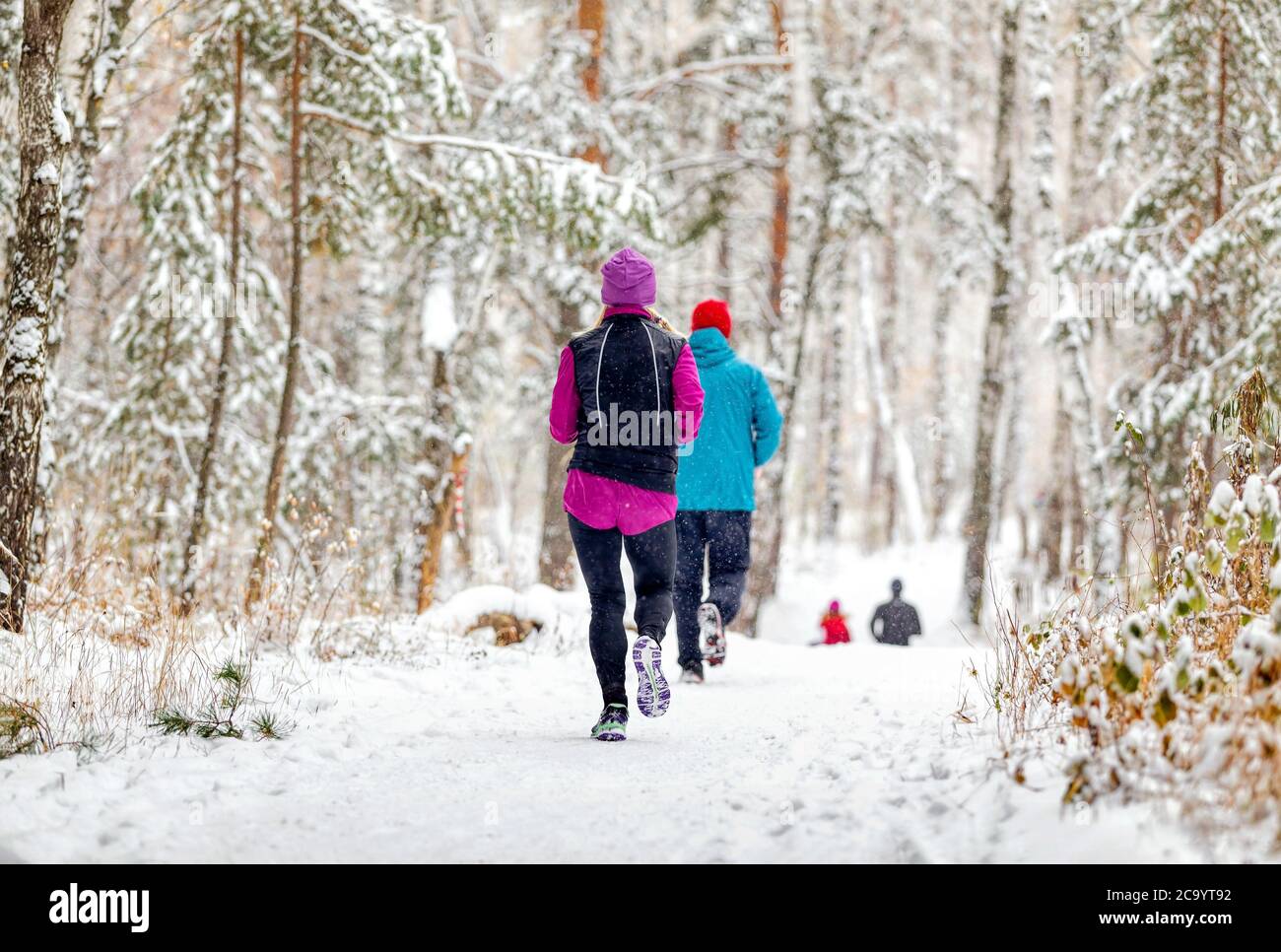 Athleten Läufer laufen Winter Trail Marathon im Wald während eines Schneefalls Stockfoto