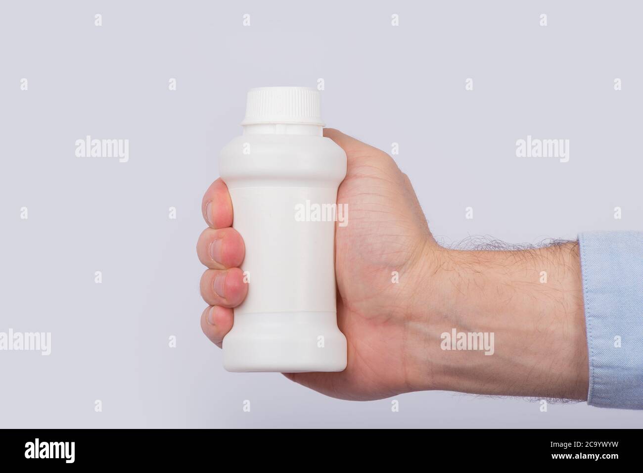 Männliche Hand hält Plastikflasche mit Pillen. Speicherplatz kopieren. Vorlage. Modell Stockfoto