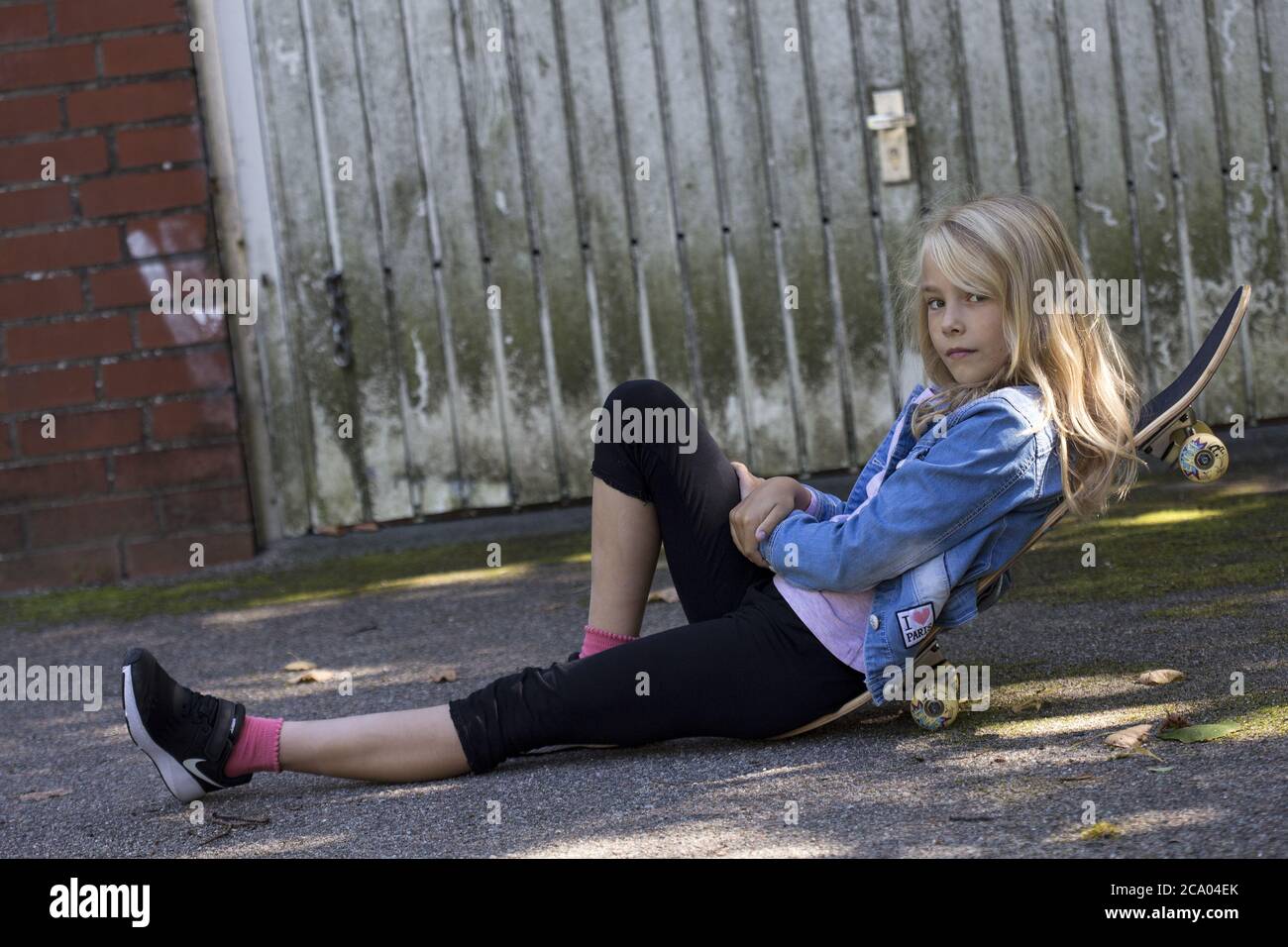 Girl (10) liegt auf einem Skateboard, Kiel, Schleswig-Holstein, Deutschland Stockfoto