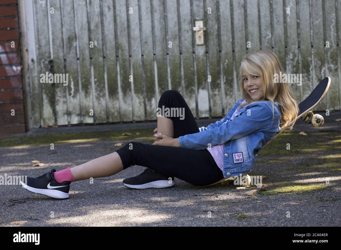 Girl (10) liegt auf einem Skateboard, Kiel, Schleswig-Holstein, Deutschland Stockfoto