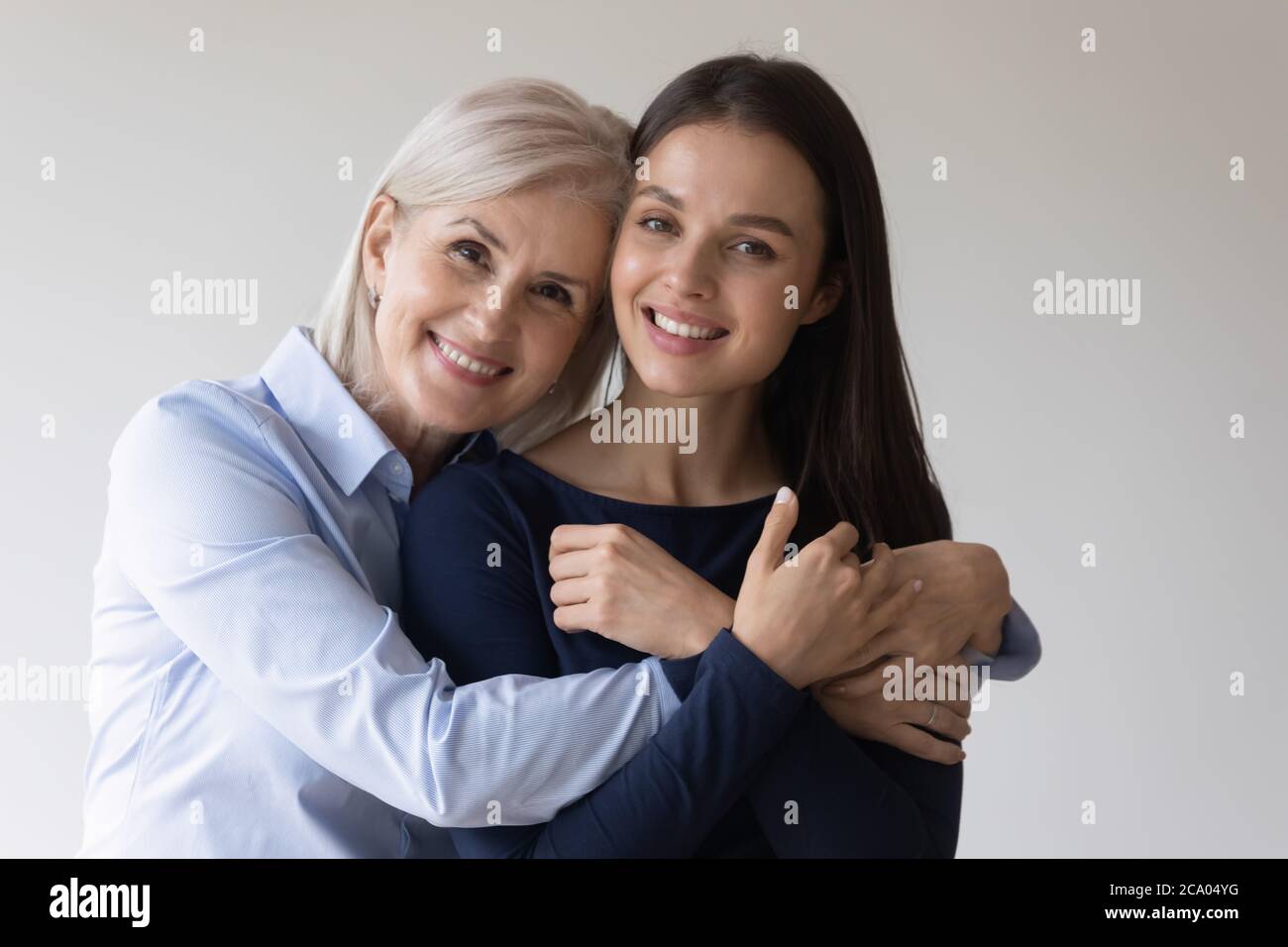 Kopfschuss Porträt reif Mutter Erwachsene Tochter umarmt Blick auf Kamera Stockfoto