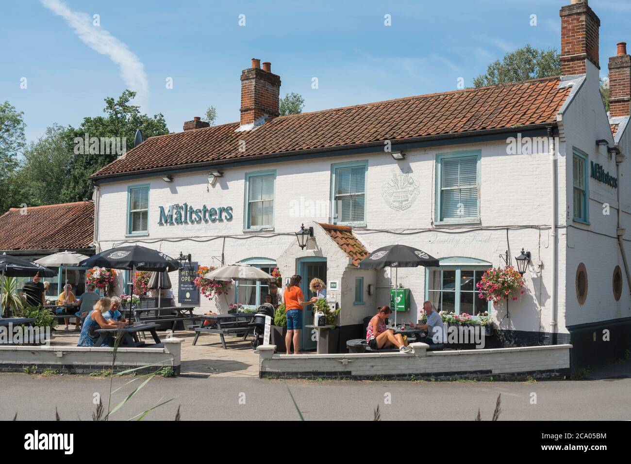 Ranworth Broad Pub, Blick im Sommer auf Leute sitzen an Tischen außerhalb der Maltsters Pub in Ranworth Broad im Herzen der Norfolk Broads, England Stockfoto