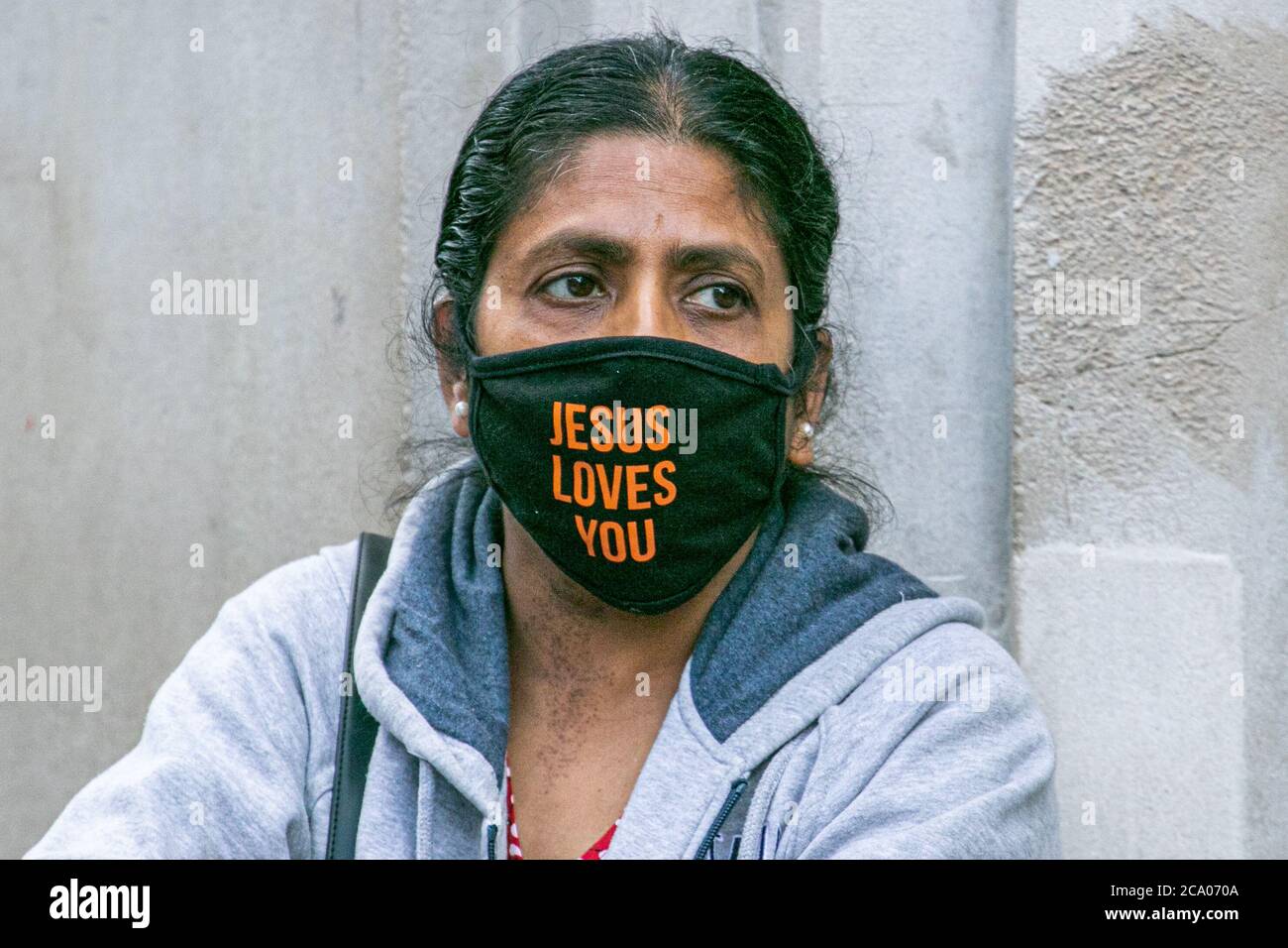 OXFORD STREET LONDON, GROSSBRITANNIEN - 3. AUGUST 2020. Eine Frau mit dem Aufdruck "Jesus liebt dich" auf ihrer schützenden Gesichtsmask in der Oxford Street. Die Regierung hat es obligatorisch für die Menschen zu tragen Gesichtsbezüge in Geschäften oder Gesicht eine £100 Geldstrafe. Kredit: amer ghazzal/Alamy Live Nachrichten Stockfoto