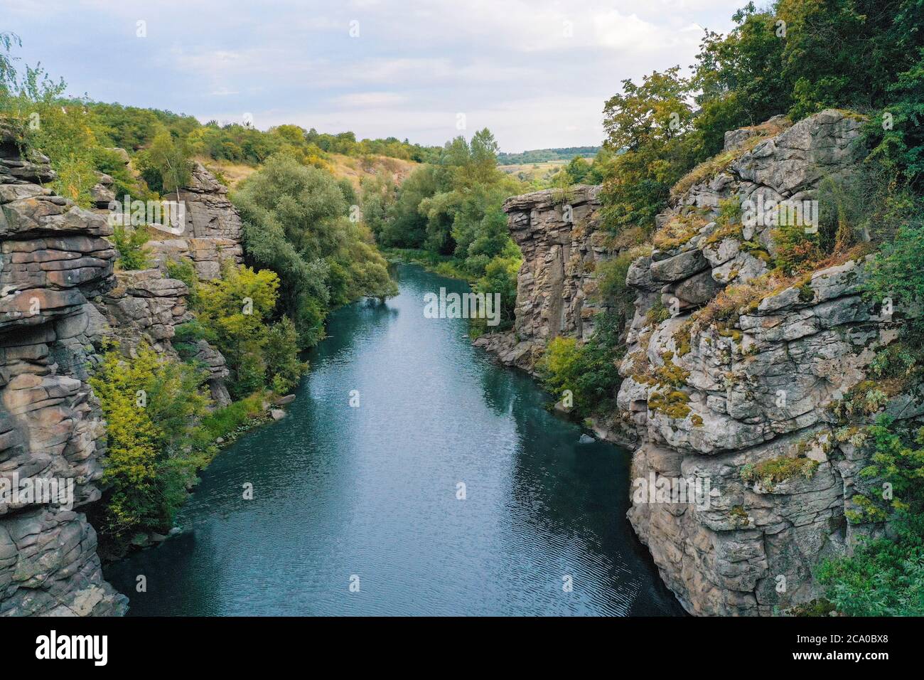 Der Fluss fließt durch eine Schlucht mit großen Steinen und Felsen Stockfoto