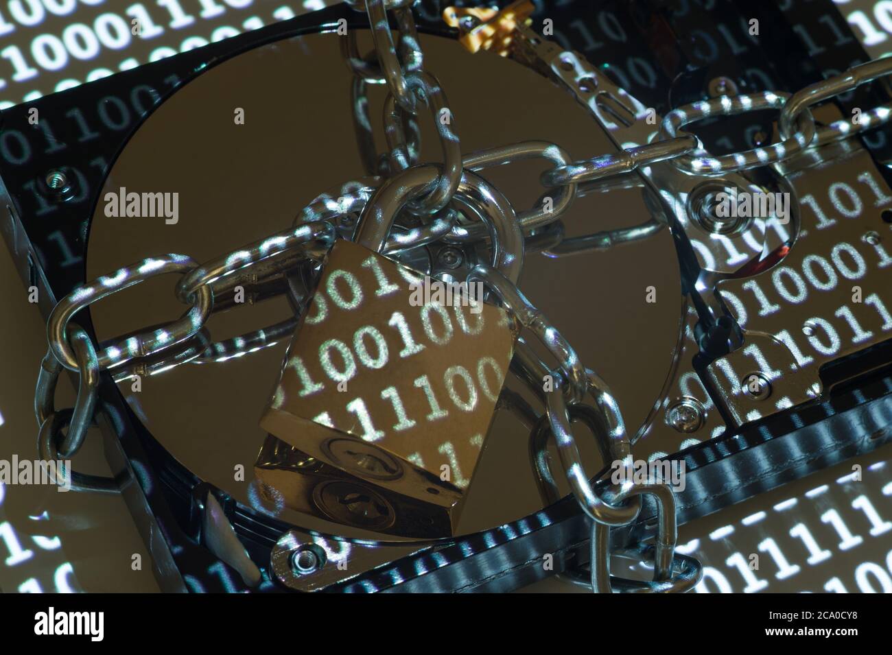 Eine 3.5'-Festplatte (HDD), die durch eine Kette und ein Vorhängeschloss gesichert ist. Stockfoto