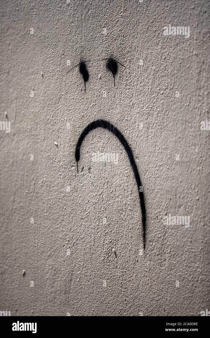 Unglückliche Gesicht Spray an einer Wand in Camden, North London, England gemalt Stockfoto