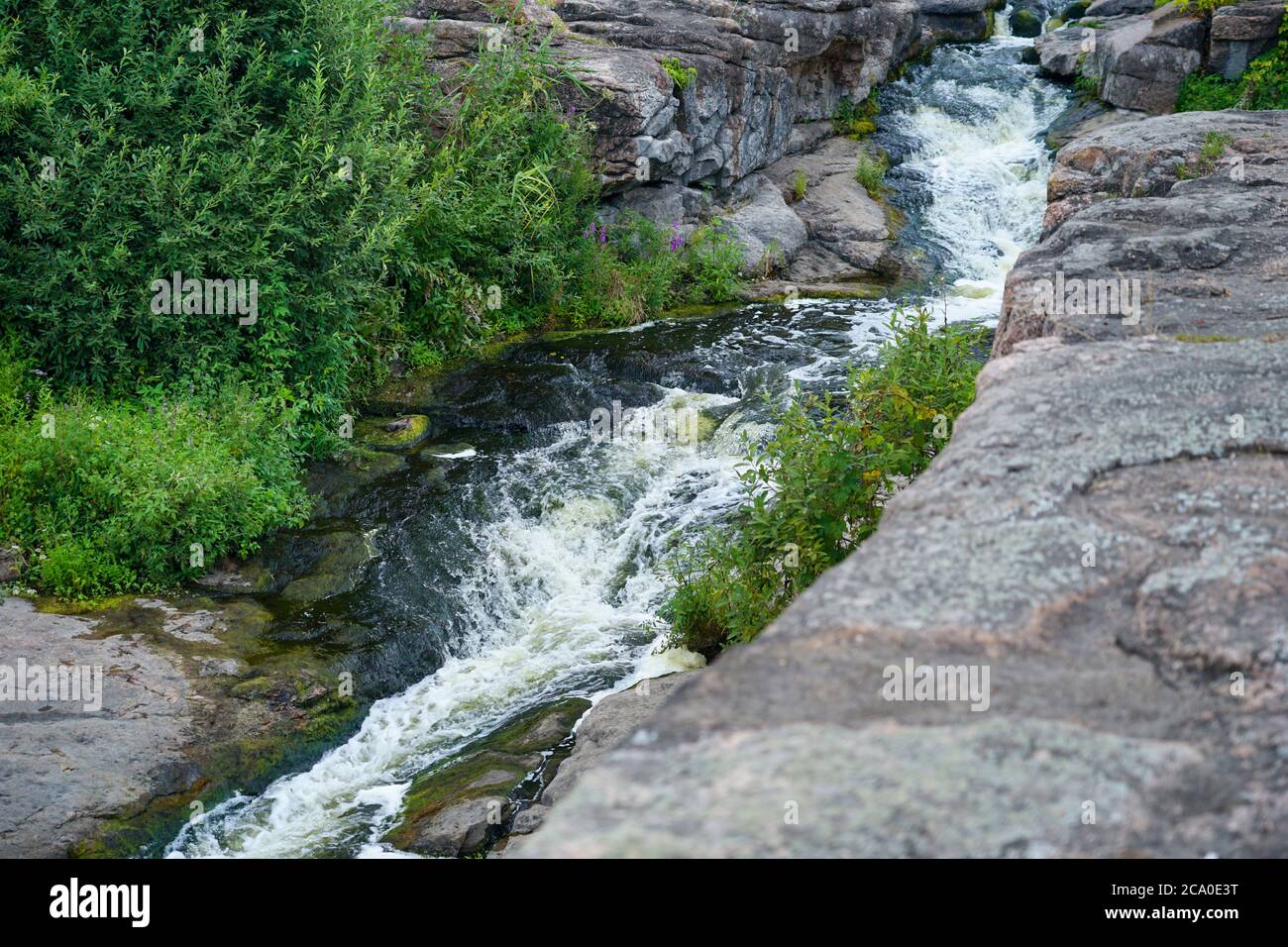 Der Fluss fließt durch eine Schlucht mit großen Steinen und Felsen Stockfoto