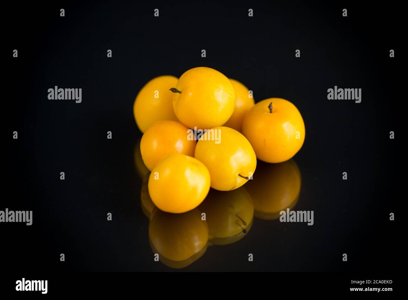 Gelbe Kirschpflaumen isoliert auf dem schwarzen Hintergrund Stockfoto