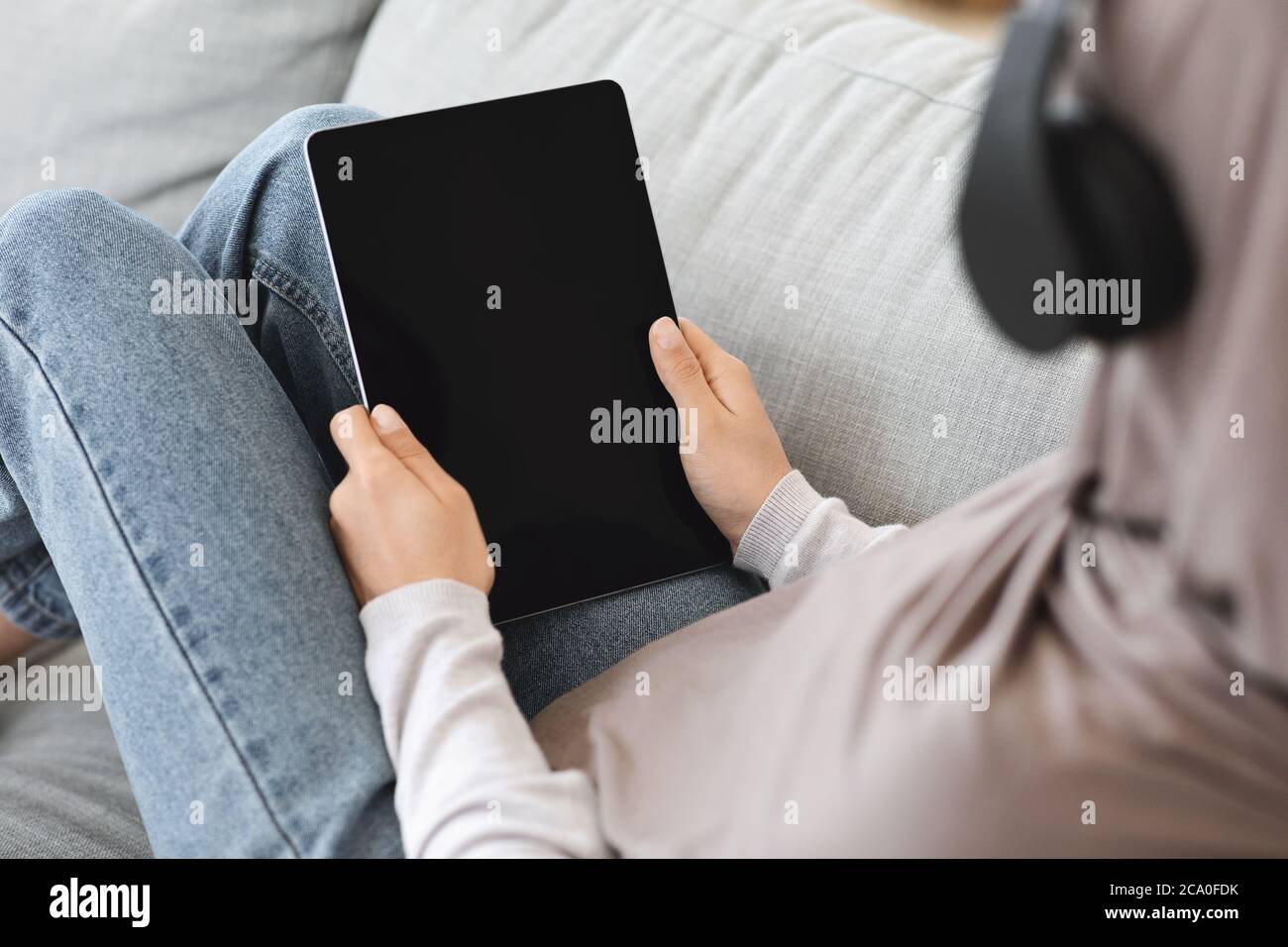 Muslimische Frau Zu Hause Entspannen, Halten Digitale Tablet Mit Schwarzem Bildschirm, Mockup Stockfoto