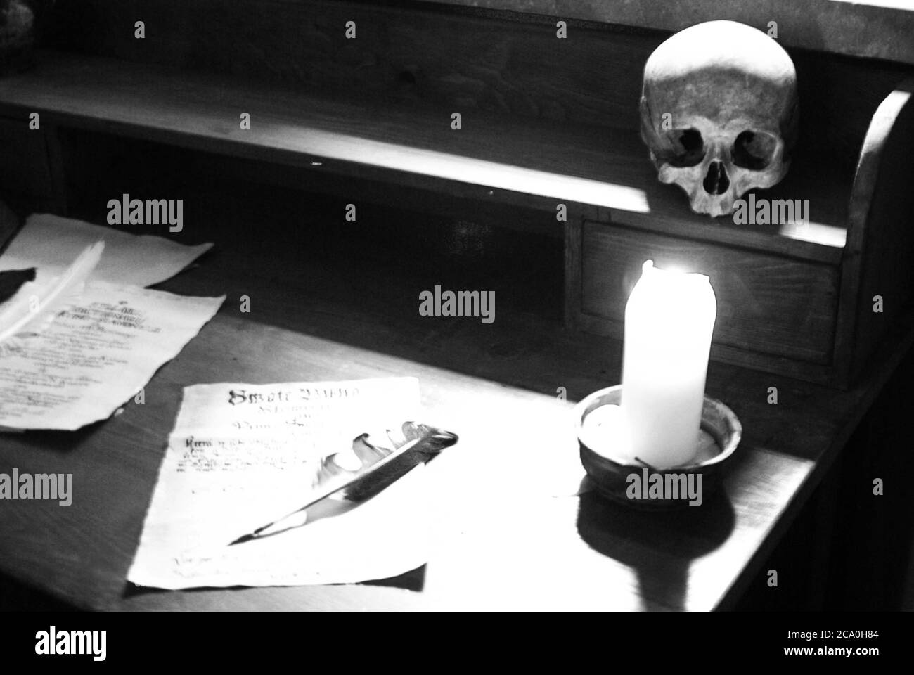 Totenkopf und Kerze auf dem Schreibtisch Stockfoto