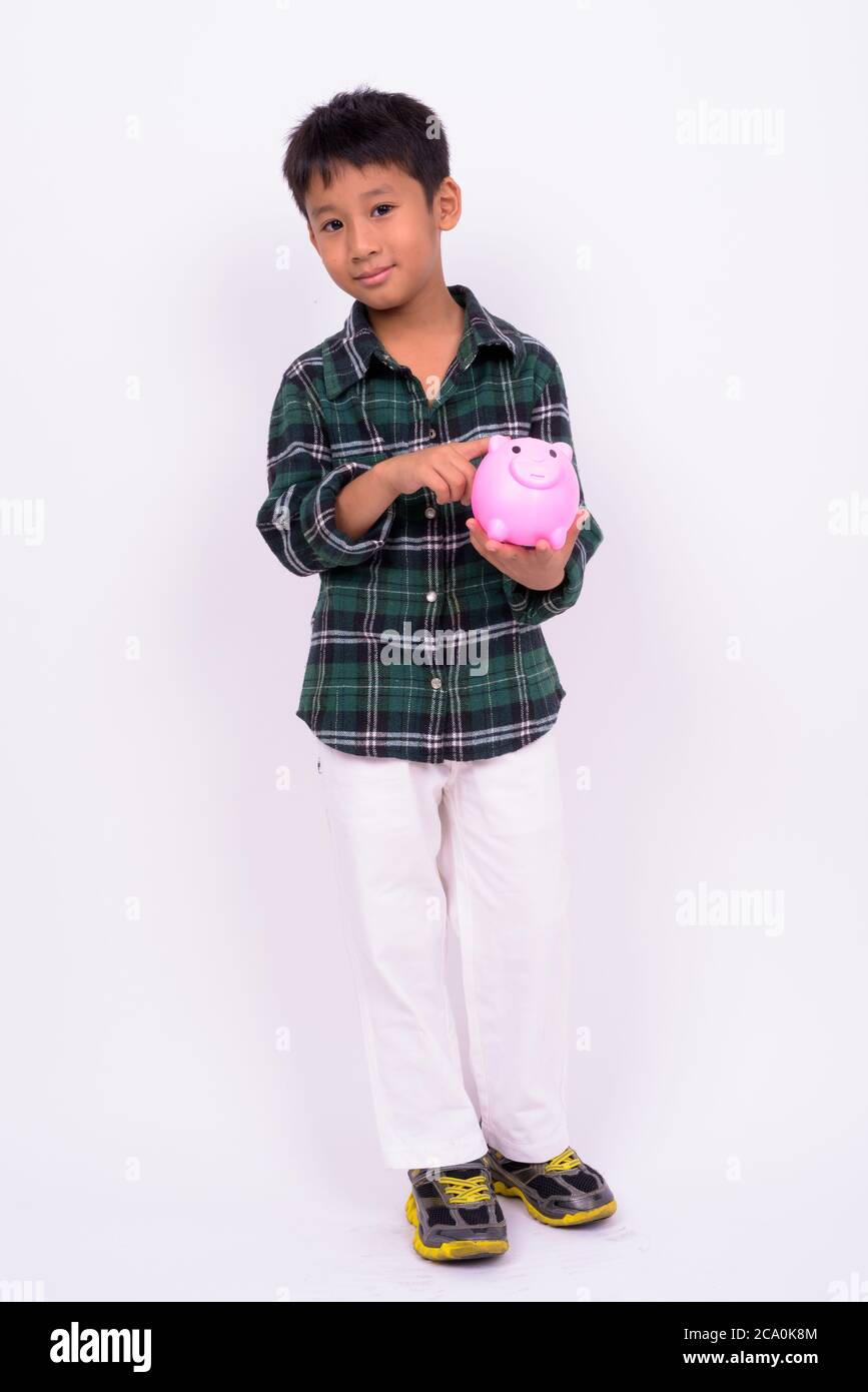 Portrait von niedlichen asiatischen Jungen mit Sparschwein Stockfoto