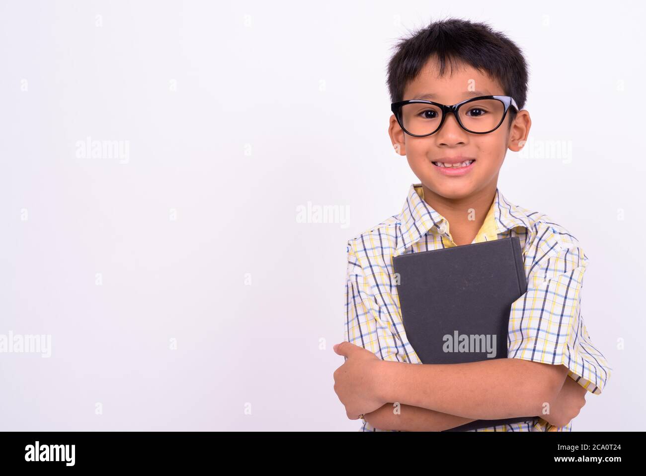 Portrait von niedlichen asiatischen Jungen tragen Brillen als Student mit Buch Stockfoto