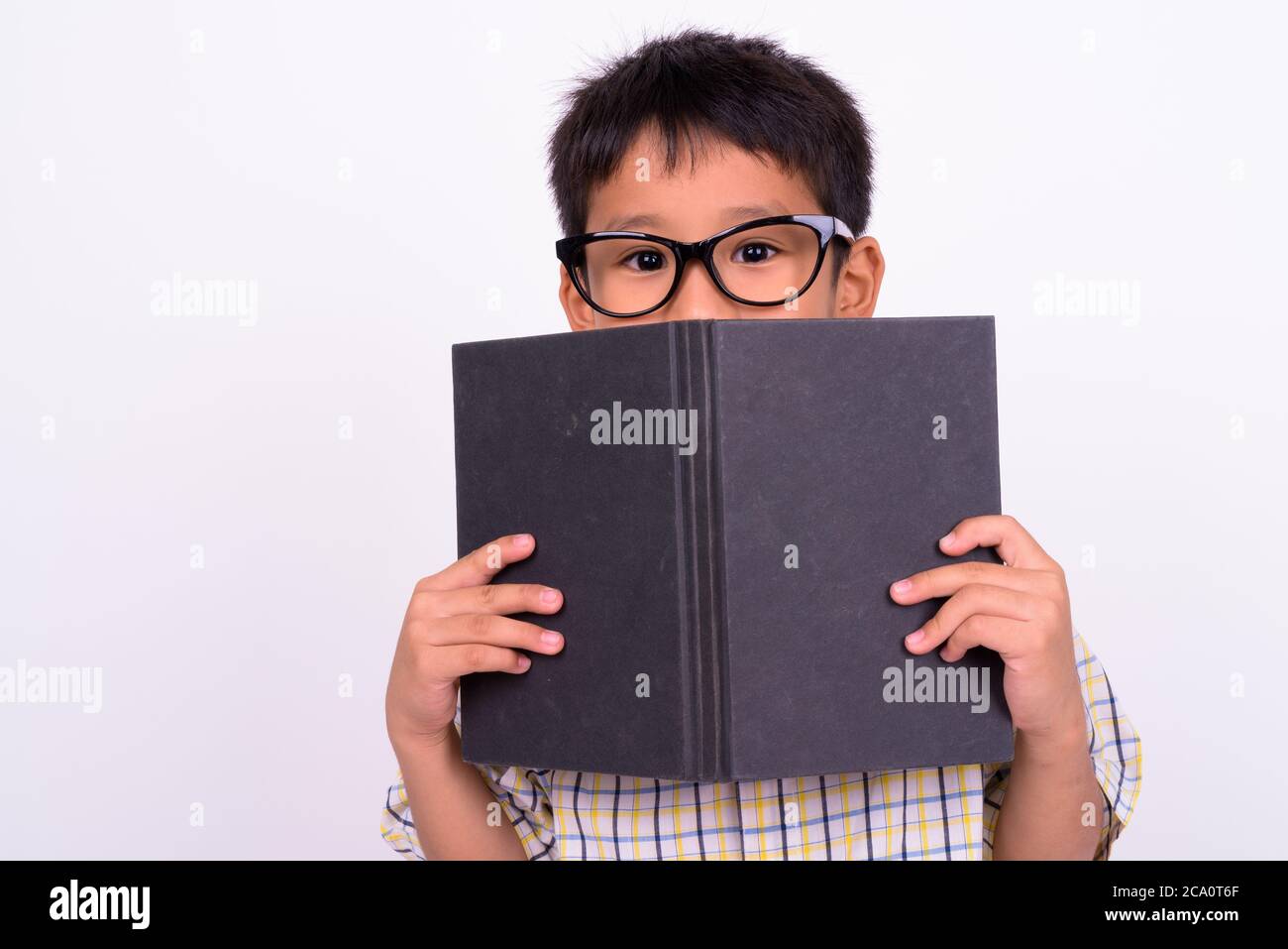 Portrait von niedlichen asiatischen Jungen tragen Brillen als Student mit Buch Stockfoto