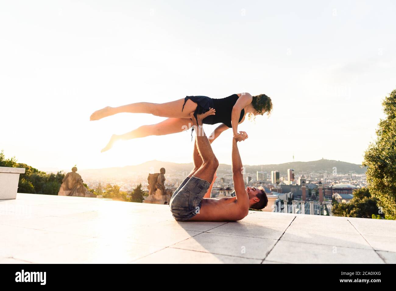 Schöner Mann und zwei Frauen machen acroyoga in der Stadt Stockfoto