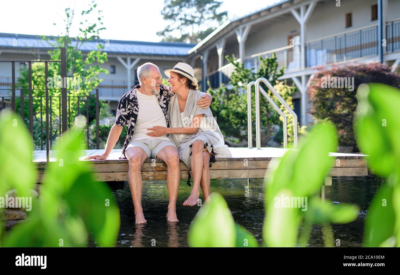 Senioren, die im Urlaub im Freien am Seehotel sitzen und Spaß haben. Stockfoto