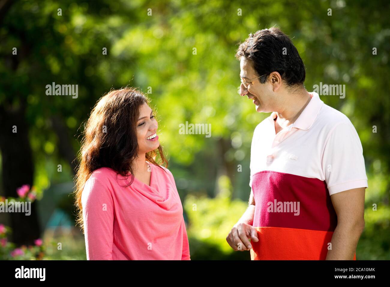 Mittelerwachsenes Paar, das im öffentlichen Park diskutiert Stockfoto