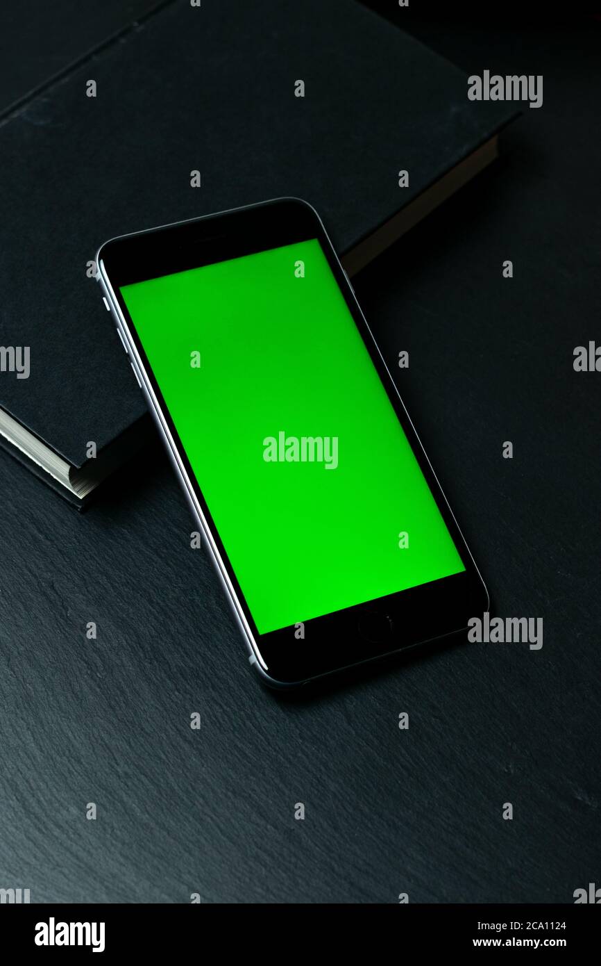 Mobiltelefon mit chromgrünem Bildschirm auf ästhetischem Hintergrund. Stockfoto