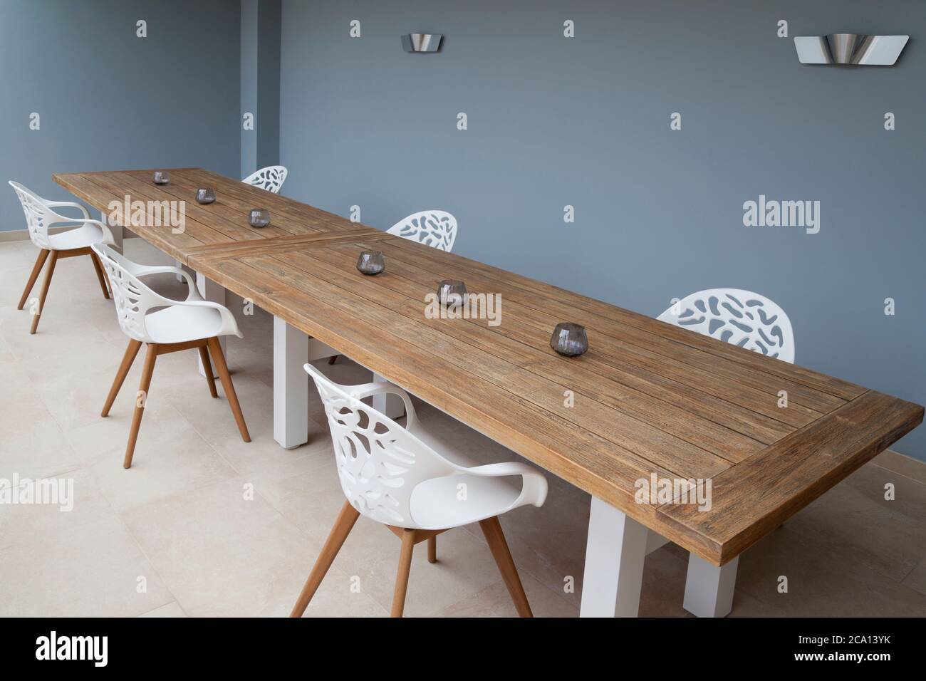 Stühle an einem Tisch mit Lücken für soziale Distanzierung in einem modernen Hotel, Restaurant oder Cafeteria Stockfoto