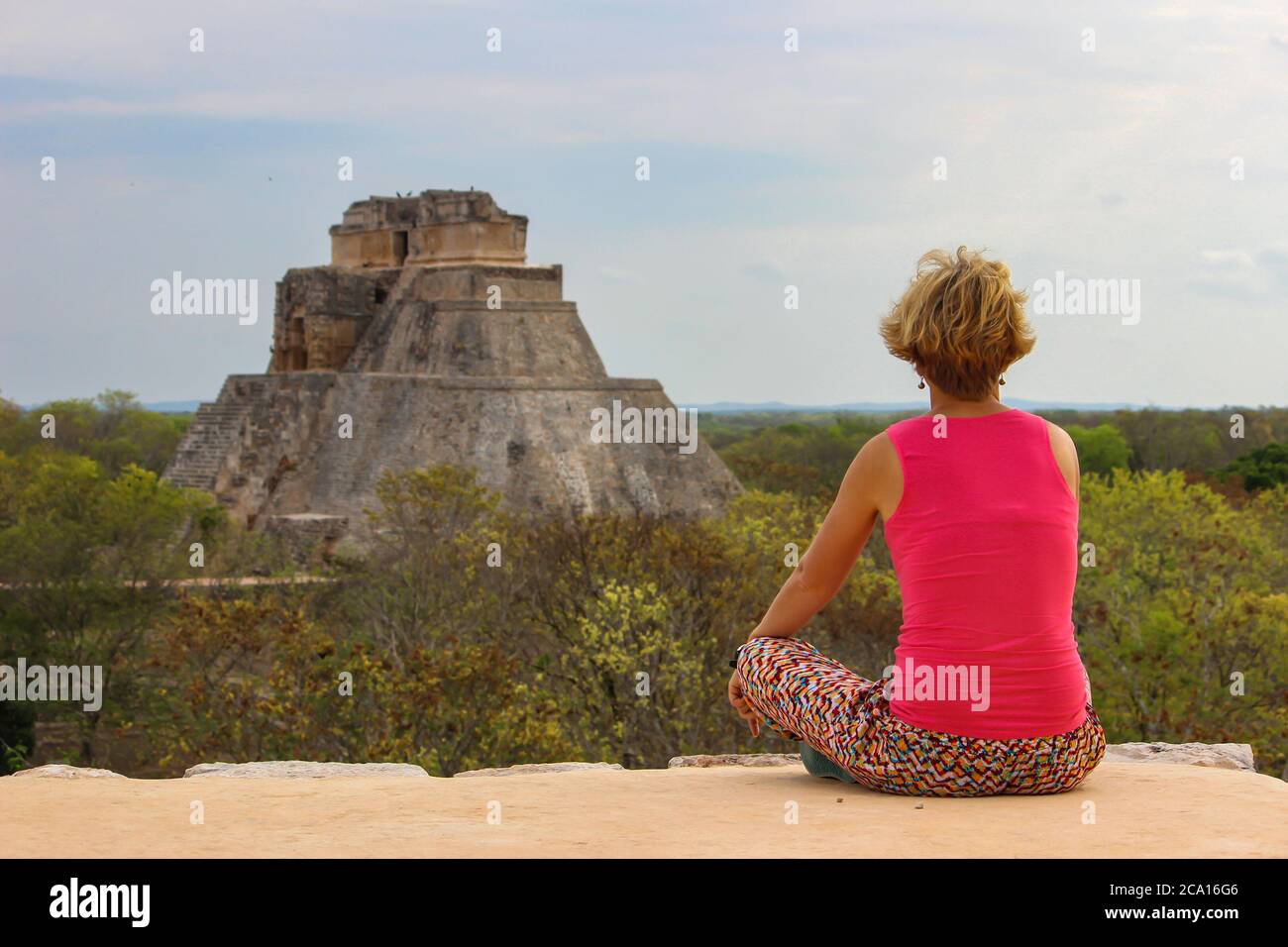 Blonde glückliche Mädchen auf ihren Urlaub in Maya-Tempel Uxmal archäologische Stätte, Mexiko. UNESCO-Weltkulturerbe. Alte Maya-Stadt und die Pyramide des Magiers in Yu Stockfoto
