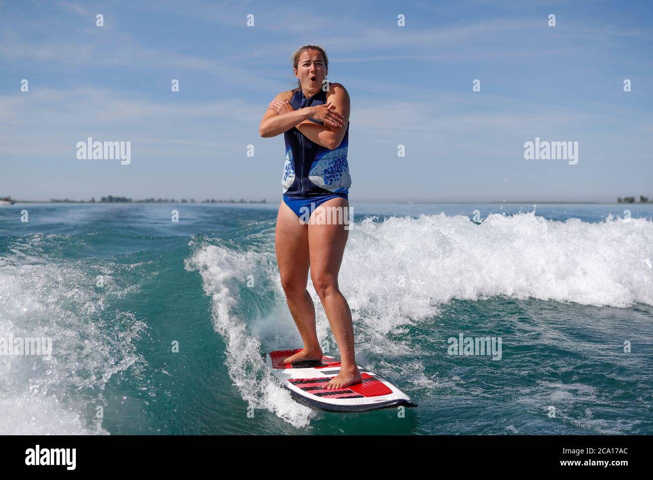 Frau wird beim Wakesurfen kalt. Stockfoto