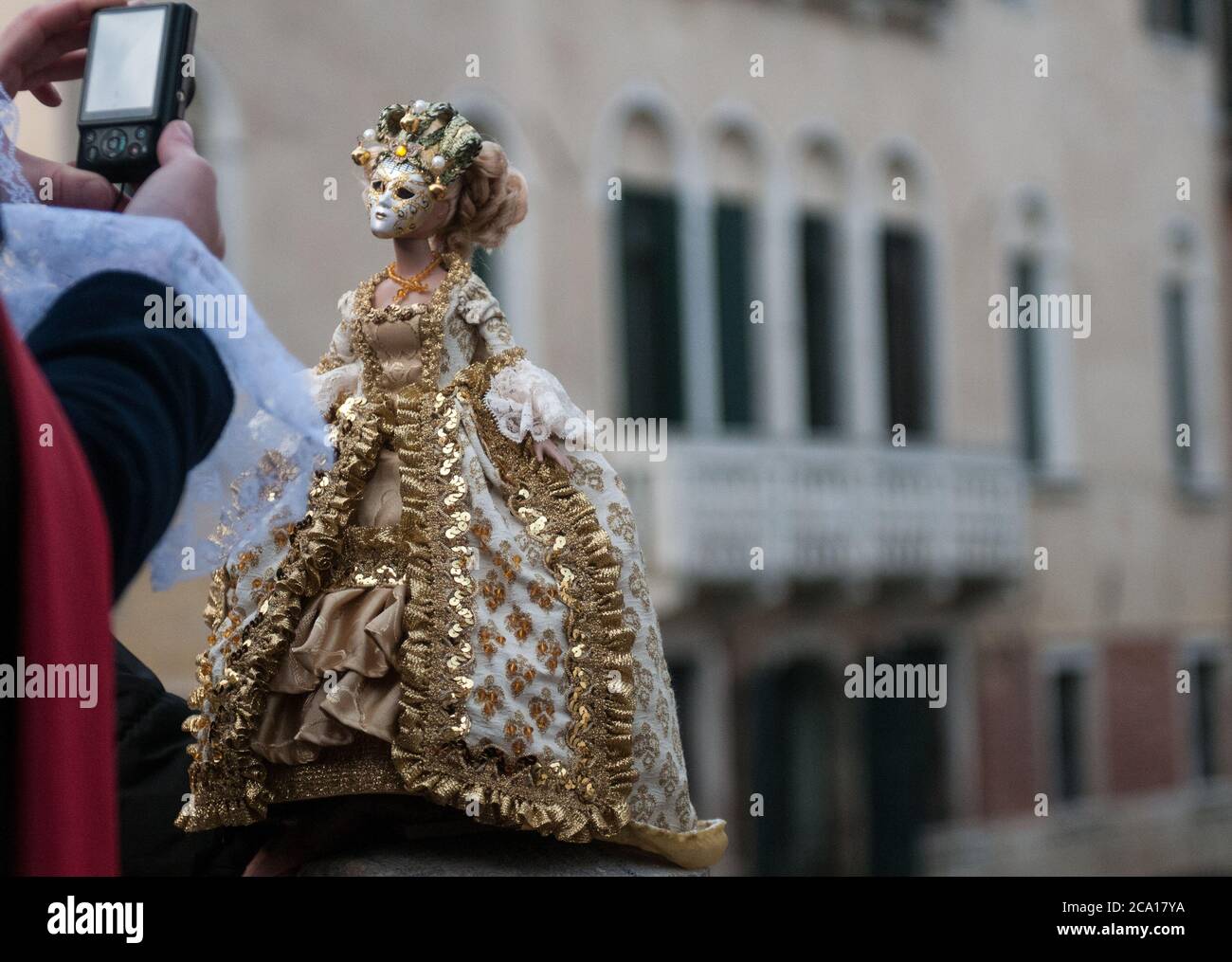 Puppe gekleidet mit einem typischen venezianischen Kostümkleid, im Hintergrund von Venedig Stockfoto