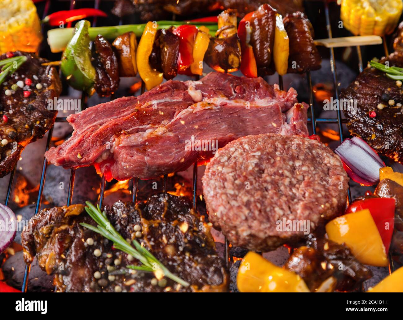 Nahaufnahme von frischem Fleisch und Gemüse auf dem Grill auf Gras platziert. Grill-, Grill- und Food-Konzept Stockfoto