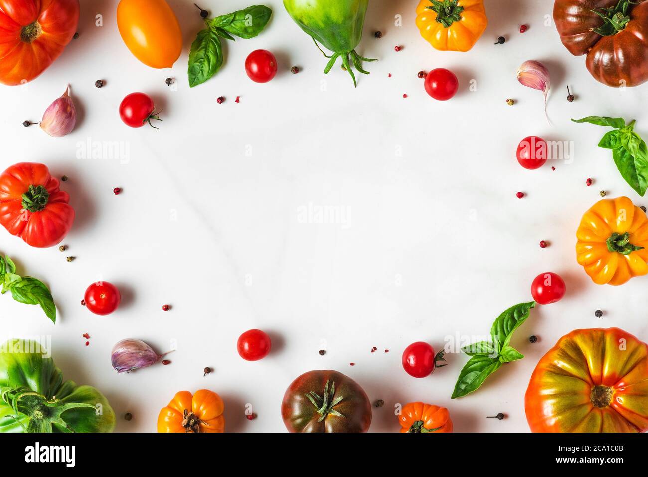 Zusammensetzung der Lebensmittel. italienische Küche Kochkonzept. Rahmen aus bunten Bio-Gemüse. Tomaten, Pfeffer, Knoblauch und Basilikum auf weißem Hintergrund. Stockfoto