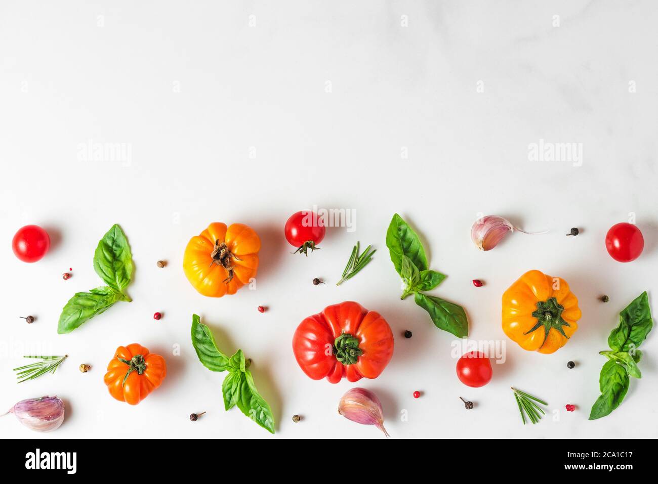 Lebensmittelzusammensetzung aus Bio-Gemüse. Tomaten, Pfeffer, Knoblauch und Basilikum auf weißem Hintergrund. italienische Küche Kochkonzept. Draufsicht mit CO Stockfoto
