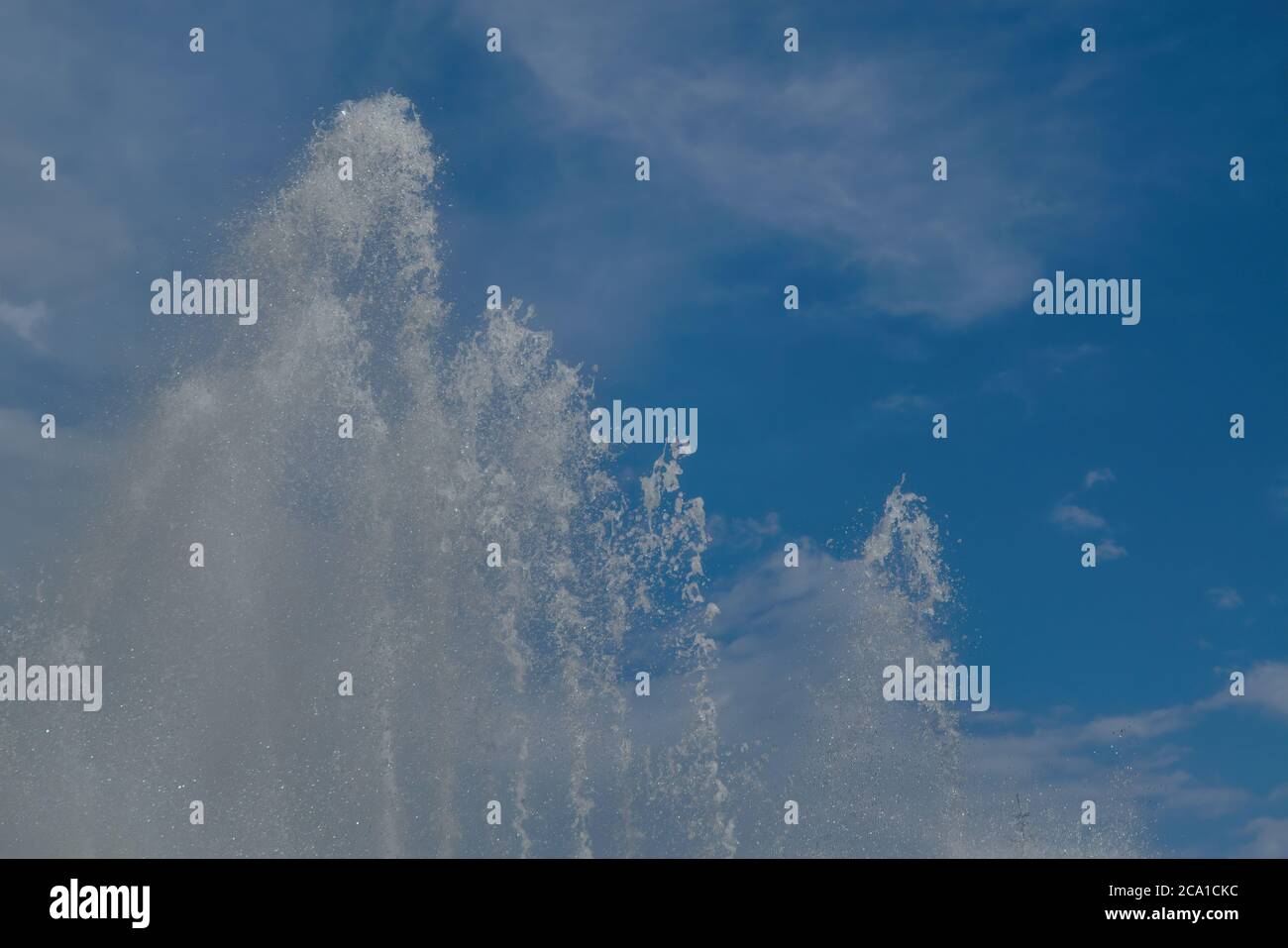 Wasserstrahlen auf einem Hintergrund des blauen Sommerhimmels Nahaufnahme. Stockfoto