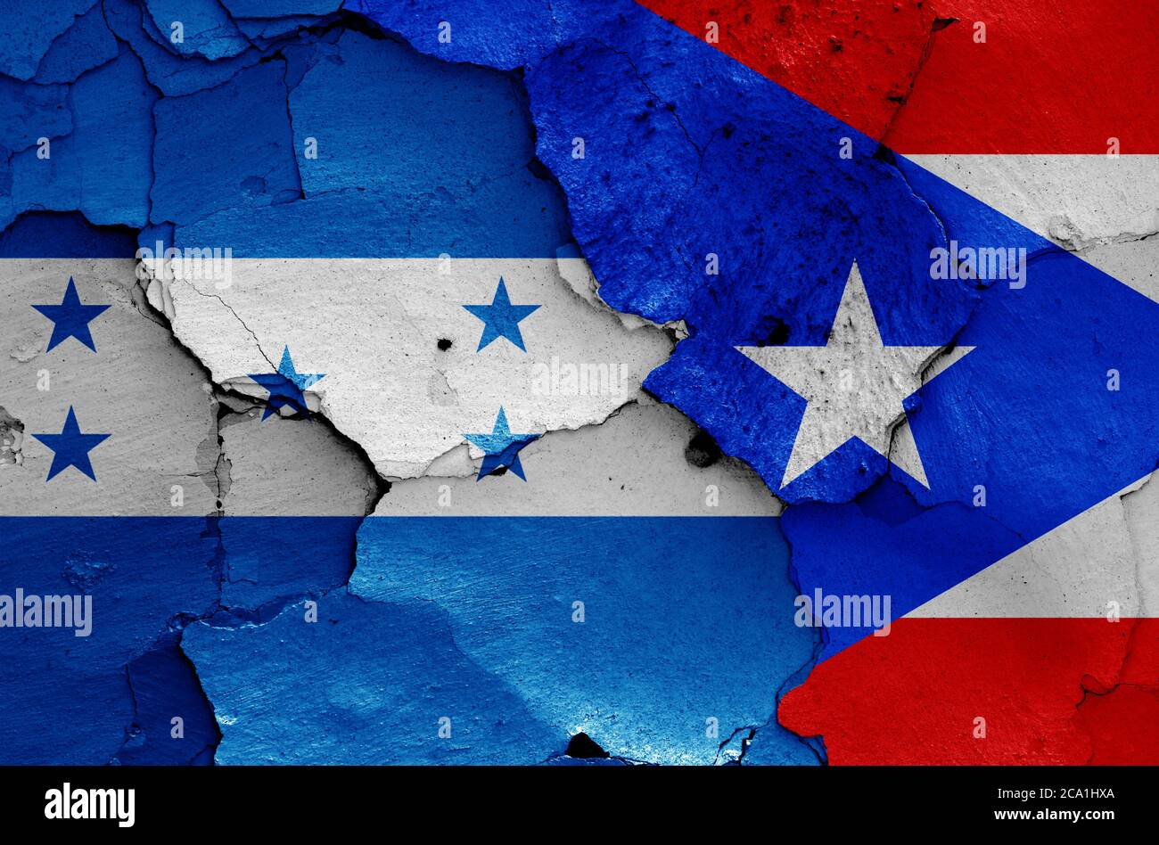 Flaggen von Honduras und Puerto Rico auf rissige Wand gemalt Stockfoto
