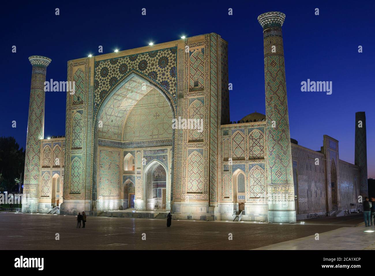 Ulug Beg Madrasah beleuchtet in der Nacht in der Registan, Samarkand, Usbekistan. Islamisches Gebäude mit Türmen und großen iwan mit Keramikfliesen dekoriert Stockfoto