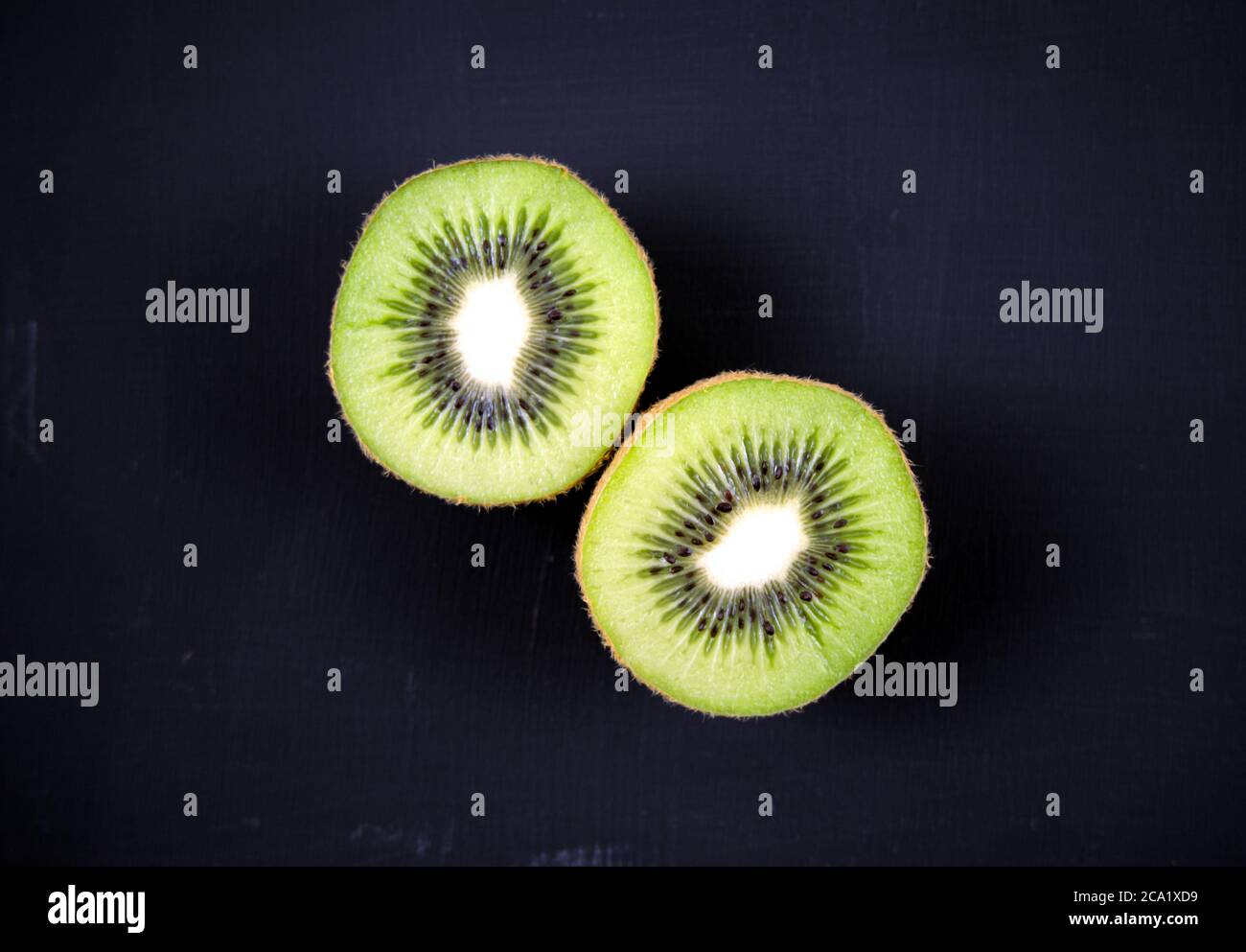 Geschnitten, geschnitten frische Kiwi Obst isoliert, Overlay auf Acryl schwarz kratzigen Grunge Malerei auf Leinwand Hintergrund. Draufsicht. Stillleben. Stockfoto