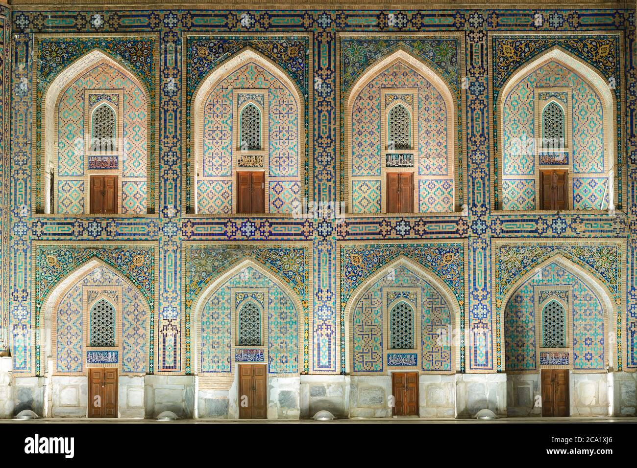 Tilya Kori Madrasah Fassade zeigt pishtaq und spandrel mit detailliertem Mosaik in der Nacht in Samarkand, Usbekistan. Islamische Architektur. Mehrere iwans. Stockfoto