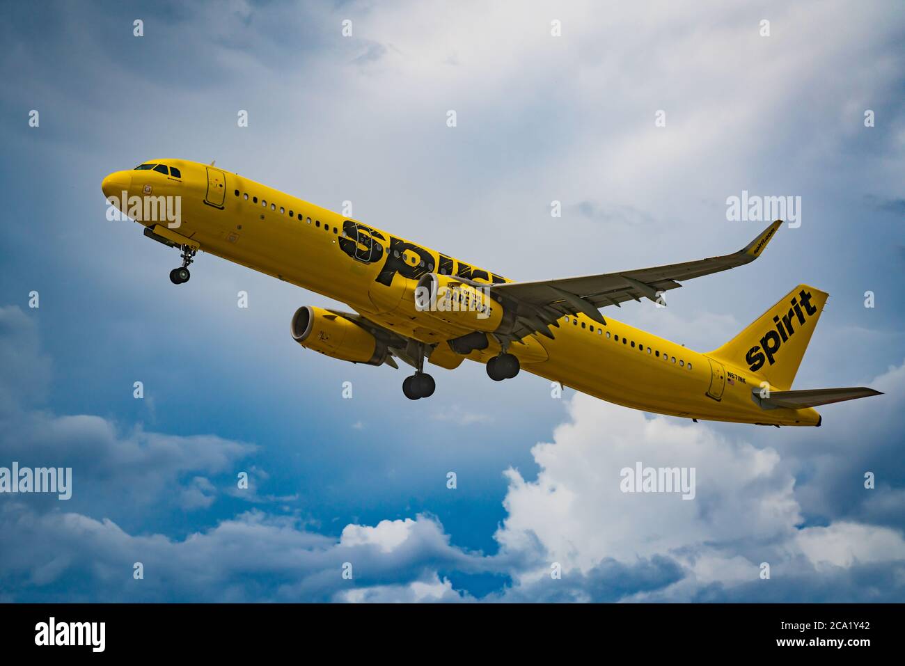 Foto eines gelb bemalten Spirit Flugzeugs auf einem weißen und blauen dramatischen Himmel Stockfoto