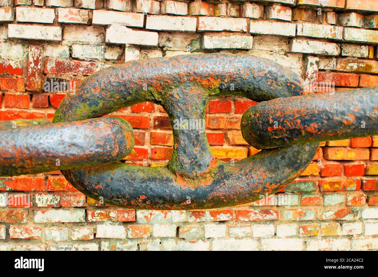 Glieder einer eisernen Kette auf einem Backstein Wand Hintergrund. Stockfoto